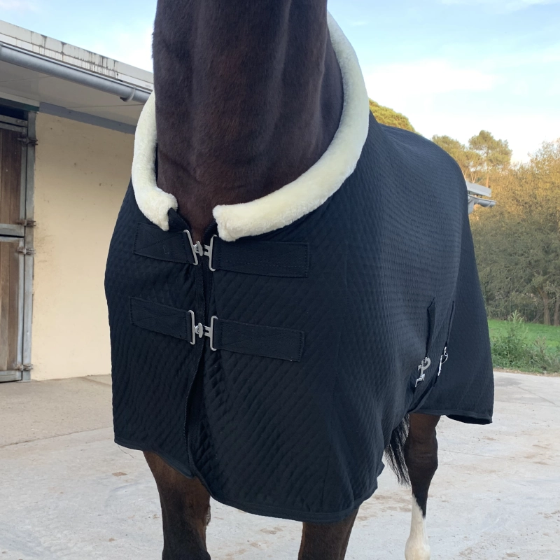Detalle del pecho de la manta de cuadra de 200gr, mostrando el sistema de cierre frontal rápido y el suave cuello de borreguillo sintético anti-rozaduras.