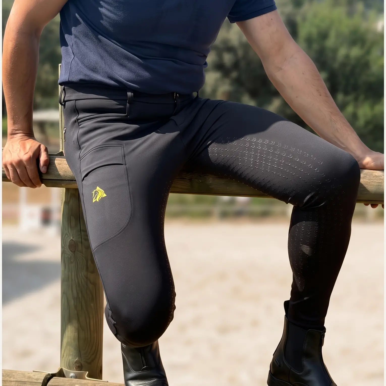 Jinete vistiendo pantalón de montar a caballo para hombre XC negro sentado en valla de hípica